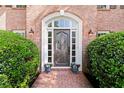 Close-up of the elegant front door with decorative glass and charming brick surround at 5620 Preserve Cir, Johns Creek, GA 30005