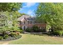Well-kept brick home with beautiful landscaping, a green lawn, and mature trees, offering great curb appeal at 5620 Preserve Cir, Johns Creek, GA 30005