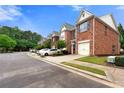 Row of charming brick townhomes, each featuring an attached one-car garage and professionally landscaped surroundings at 5654 Lawley Dr, Alpharetta, GA 30022