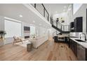 Bright open-concept living room with hardwood floors, fireplace, and modern kitchen featuring stainless steel appliances at 2396 Sunset Ne Dr, Atlanta, GA 30345