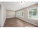 Open-concept living area featuring hardwood floors and ample natural light from the two large windows at 261 Hemphill School Nw Rd, Atlanta, GA 30331
