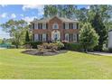 Charming brick home featuring a well-kept lawn, symmetrical design, and mature trees at 4257 Edgewater Nw Dr, Kennesaw, GA 30144