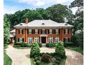 Elegant red brick home with manicured landscaping and a circular driveway at 3370 Habersham Nw Rd, Atlanta, GA 30305