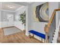 Entryway featuring wood-look floors, bench seating, and modern artwork; stairs to the right at 3510 Meadow Grass Dr, Dacula, GA 30019