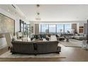 Spacious living room with hardwood floors, stylish furniture, and floor-to-ceiling windows with city views at 3344 Peachtree Ne Rd # 3601, Atlanta, GA 30326