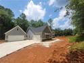 View of the home and detached two car garage with matching siding, stone accents and concrete driveway at 879 Highway 101 N, Dallas, GA 30157