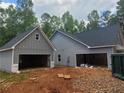 View of the rear of this new construction shows the attached garage and matching siding and roofing at 879 Highway 101 N, Dallas, GA 30157