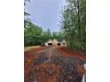 Exterior view showcasing the home's attached two-car garages and gravel driveway during new construction at 879 Highway 101 N, Dallas, GA 30157