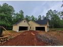 New construction with an attached two-car garage featuring matching board and batten siding and black roof at 879 Highway 101 N, Dallas, GA 30157