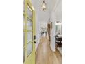 Inviting foyer with hardwood floors, bright walls, a yellow front door, and access to a bathroom and staircase at 2244 Spink Nw St, Atlanta, GA 30318