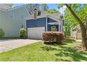 Blue home with white garage door, neat landscaping, and inviting front yard with healthy green grass at 2244 Spink Nw St, Atlanta, GA 30318
