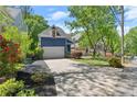 A blue two-story home boasts a well-kept front yard, mature trees, and a paved driveway, showcasing curb appeal at 2244 Spink Nw St, Atlanta, GA 30318