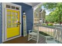 Inviting front porch featuring a bright yellow door, rocking chairs, and a welcome sign at 2244 Spink Nw St, Atlanta, GA 30318