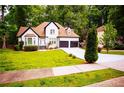 Beautiful two-story home with an attached two-car garage and green lawn at 6147 Pritchett Dr, Powder Springs, GA 30127