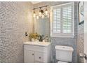 Stylish half-bathroom featuring unique wallpaper, modern fixtures, and ample natural light from the window at 321 Hickory Sw Walk, Marietta, GA 30064