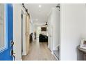 Bright hallway featuring light wood floors, white walls, and a sliding barn door to the living spaces at 321 Hickory Sw Walk, Marietta, GA 30064