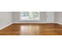 Bright living room with gleaming hardwood floors, large window, and fresh neutral paint at 2740 Pasco Se Ln, Atlanta, GA 30316