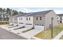 Rear view of new townhomes featuring attached garages, private driveways, and well-maintained exteriors at 460 Reflection Dr # 21, Stockbridge, GA 30281