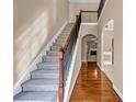 Bright foyer featuring hardwood floors, staircase with iron railings, and elegant archways at 4499 Bellemeade Dr, Douglasville, GA 30135