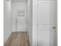 Clean hallway with light-colored wood floors and white walls at 5853 Greystone Dr, Lithonia, GA 30058