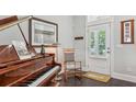 Inviting entryway with piano, rocking chair, and bright white door at 613 Brennan Dr, Decatur, GA 30033