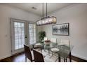 Modern dining room with a glass table, stylish lighting, and access to the outdoor area at 3107 Woodland Ln, Alpharetta, GA 30009