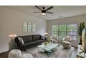 Comfortable living room featuring a ceiling fan, plush seating, and a large window at 3107 Woodland Ln, Alpharetta, GA 30009