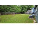 Spacious backyard with a large grassy area, wooden fence, and a fire pit perfect for outdoor gatherings at 3236 Grove Nw Trl, Acworth, GA 30101