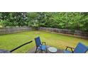 Large, fenced backyard with lush green grass and patio seating, creating a relaxing outdoor space at 3236 Grove Nw Trl, Acworth, GA 30101
