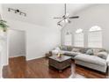Bright living room features vaulted ceilings, large arched windows, hardwood floors, and a comfortable gray sectional sofa at 3607 Anna Nw Ln, Kennesaw, GA 30144