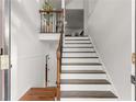 Bright foyer showcases staircase with wooden steps and white risers, contrasted with dark wood handrail and iron balusters at 3607 Anna Nw Ln, Kennesaw, GA 30144