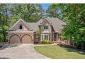 Charming home featuring a lush green lawn, a two-car garage, and a welcoming stone walkway at 1336 Amberwood Dr, Woodstock, GA 30189