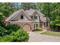 Beautiful exterior of home featuring an arched entry and side-facing garage with well-maintained landscaping at 1336 Amberwood Dr, Woodstock, GA 30189