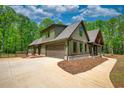 Attractive house featuring an attached two-car garage and a charming front porch with wooden accents at 60 Browning Shoals Rd, Social Circle, GA 30025