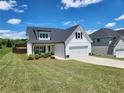 Charming white home featuring a well-maintained lawn and a two-car garage with a blue sky at 1132 Red Bud Cir, Villa Rica, GA 30180