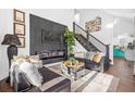 Cozy living room with modern fireplace, staircase, and dark leather seating at 1554 Cardinal Rd, Jonesboro, GA 30238