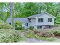 Charming two-story home with a light blue door and beautifully landscaped front yard surrounded by lush green trees at 3460 Wycherly Ne Ct, Brookhaven, GA 30319