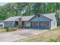 View of blue home with two-car garage at 554 Cana Of Galilee Ct, Tucker, GA 30084