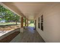 View of an expansive covered porch with stylish tiled flooring and elegant wooden support beams at 899 Marshall Fuller Rd, Dallas, GA 30157