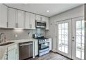 Well-lit kitchen with stainless steel appliances, subway backsplash and french doors at 2302 Colonial Ne Dr, Brookhaven, GA 30319
