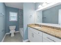 Bathroom featuring a stylish vanity with granite countertop and a beautifully tiled shower at 4175 Danforth Sw Rd, Atlanta, GA 30331