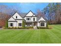 Charming two-story home featuring a manicured lawn with verdant landscaping and elegant architectural details at 4370 Freys Farm Nw Ln, Kennesaw, GA 30152