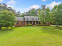 Expansive front yard of a brick home featuring lush lawn and mature trees offering a serene and inviting curb appeal at 145 Havenbrooke Ct, Fayetteville, GA 30214