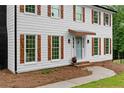 Close up of a charming two-story home featuring white siding and decorative shutters at 6659 Manoleta Dr, Lithonia, GA 30038