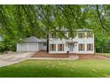 Beautiful two-story home with white siding, shutters, attached garage, and landscaped front yard at 6659 Manoleta Dr, Lithonia, GA 30038