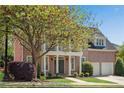 Attractive brick home with a columned porch, two-car garage, and mature shade trees at 1555 Heritage Trl, Roswell, GA 30075