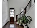 Bright foyer with a dark wood front door, hardwood floors, staircase, and neutral paint at 3180 Andover St, Cumming, GA 30028