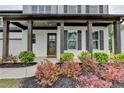 Charming front porch with dark wood columns and trim, surrounded by a beautifully landscaped garden at 3180 Andover St, Cumming, GA 30028