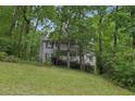 Two-story house with a white balcony, surrounded by lush green trees and vegetation at 3876 Winners Ct, Marietta, GA 30062