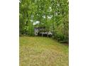Two-story home with a gray exterior featuring double porches framed by mature trees and lawn at 3876 Winners Ct, Marietta, GA 30062